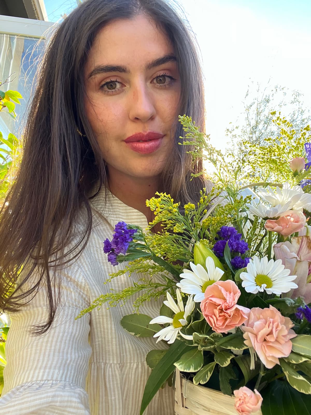 Alexandra Alemany holding a colorful bouquet of flowers