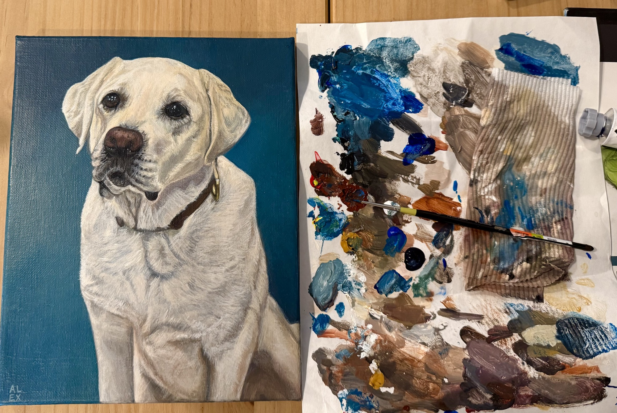 Labrador portrait beside Alexandra's paint palette and brush